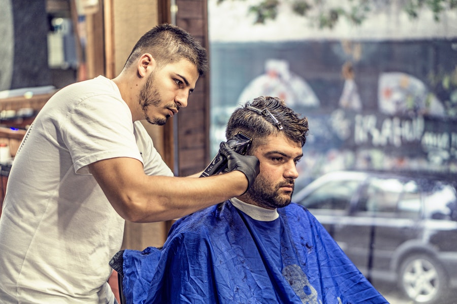 Male hairdresser cuts another man's hair