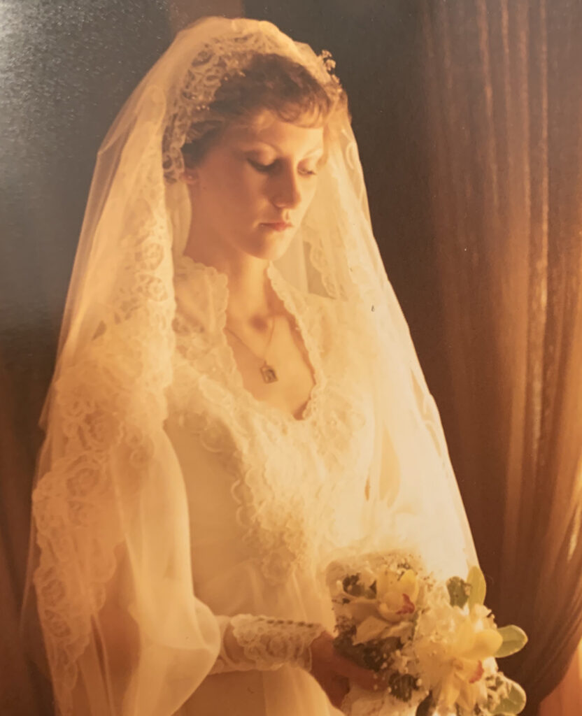 Woman in white wedding dress looks solemn on her wedding day.