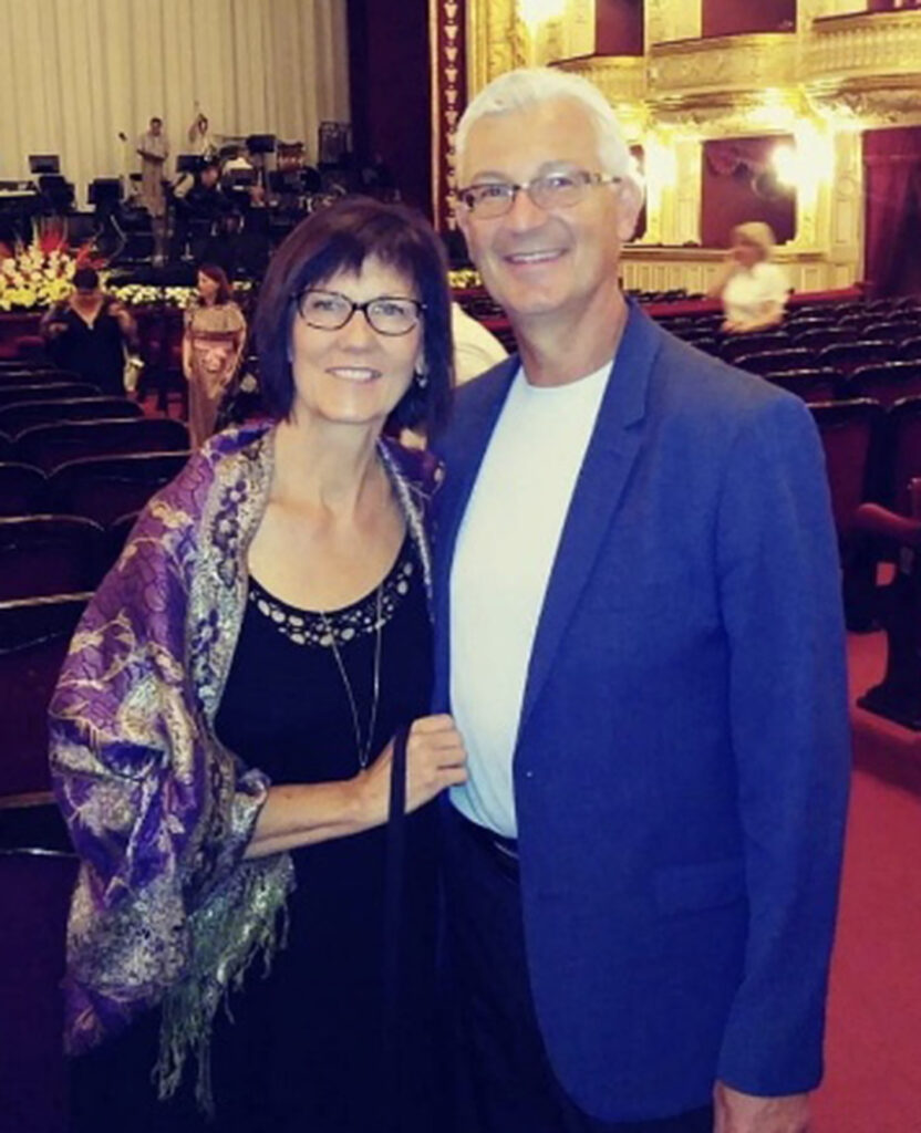 Man and woman pose together holding hands in a church.