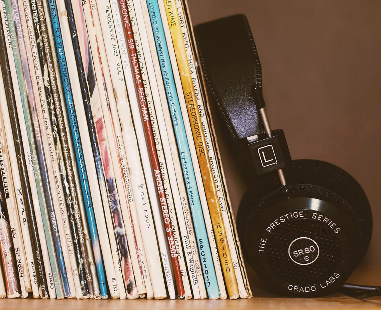 vinyl records on a shelf with a pair of black headphones
