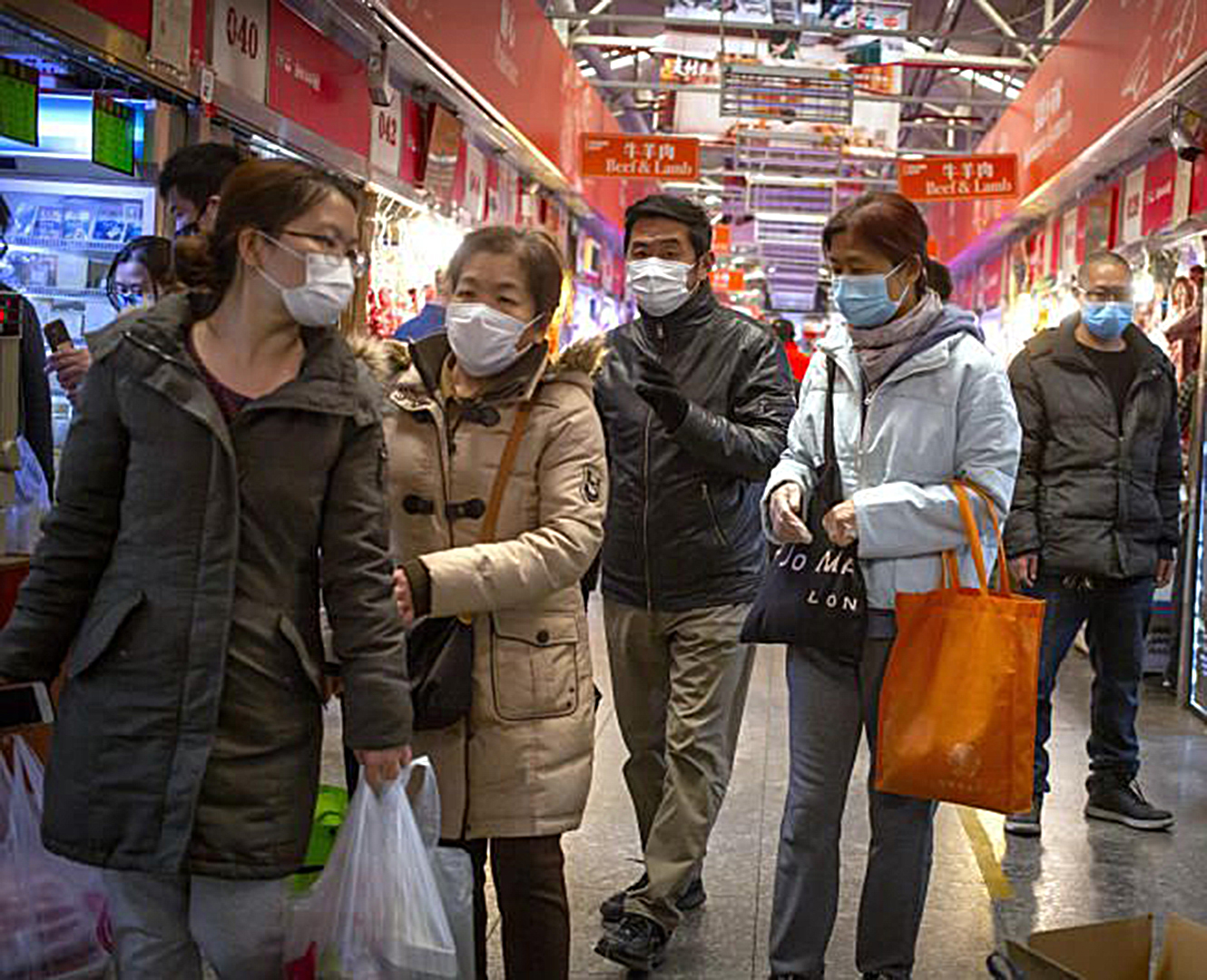 Asian people walk in market in China wearing face masks