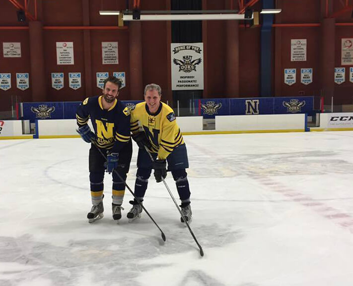 Two men stand in NAIT arena at the beginning of a game of hockey