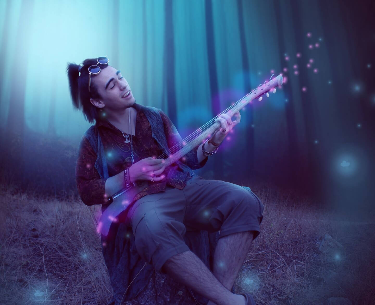 man plays guitar in enchanted forest