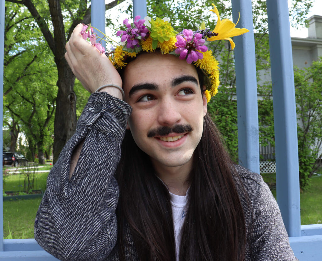 Man poses wearing a handmade flower crown
