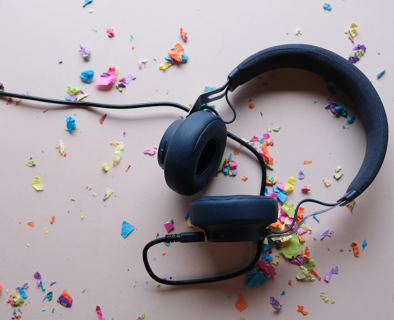 headphones sit on a desk with confetti