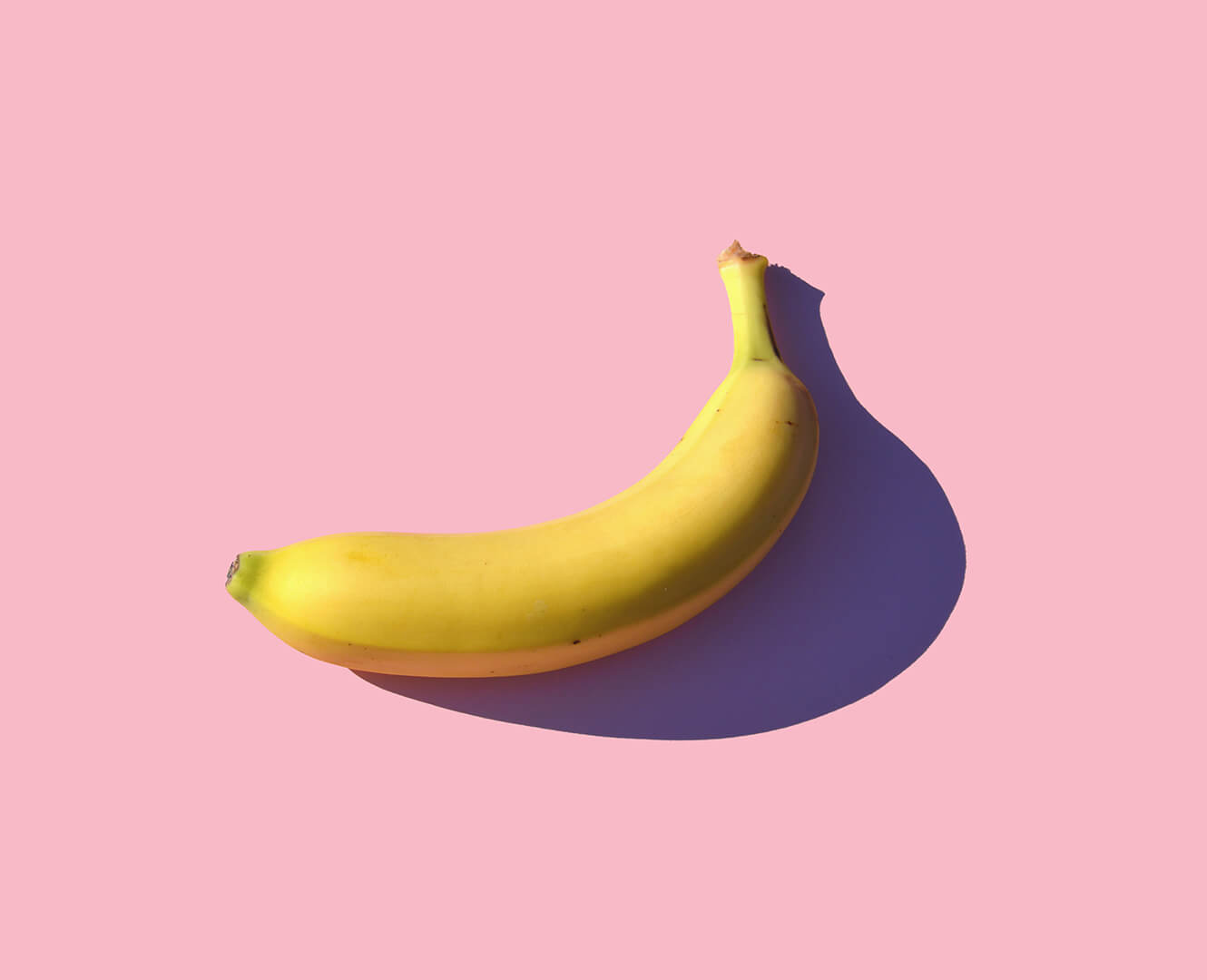 Banana on pink backdrop.