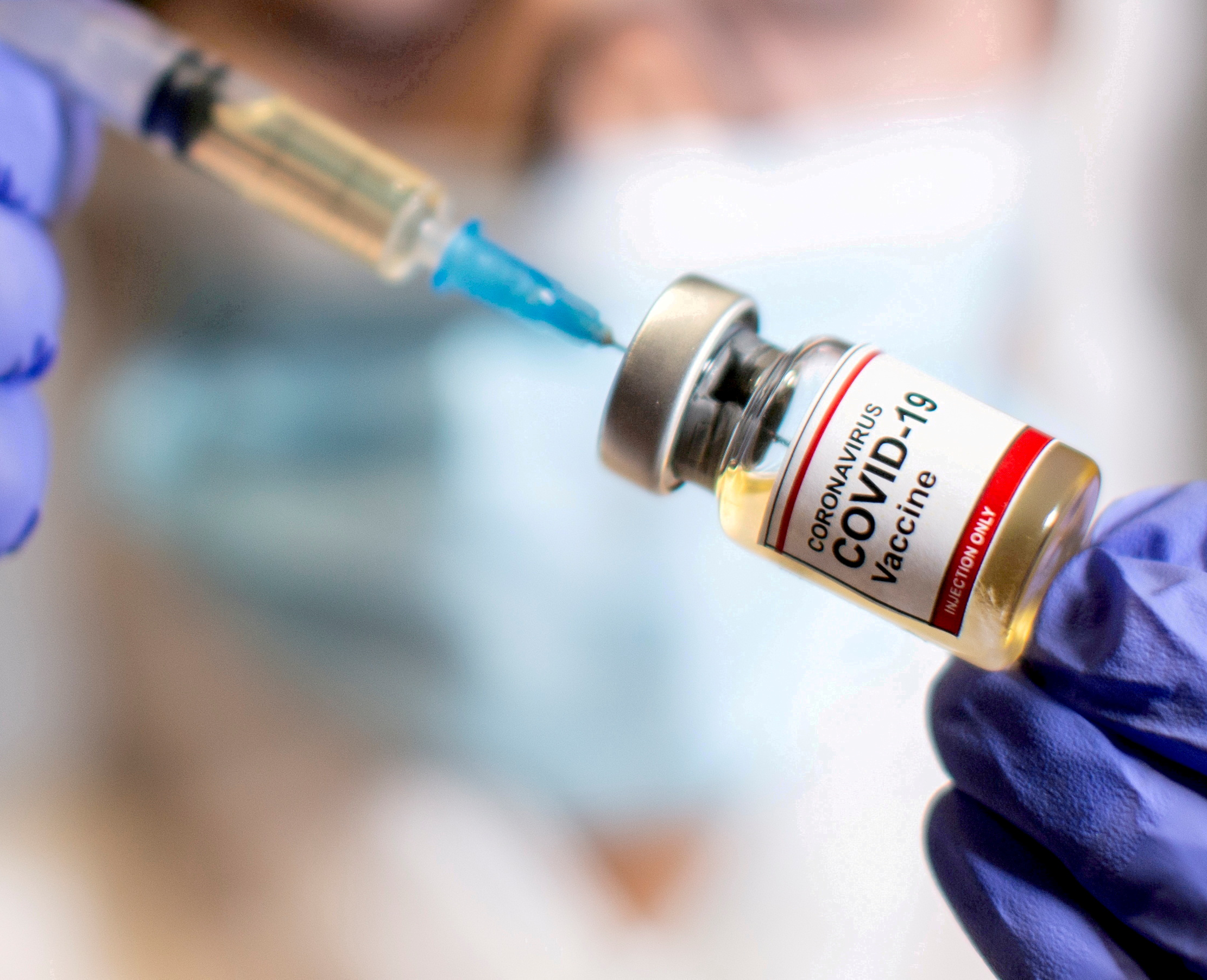 A needle going into a bottle of the COVID-19 vaccine