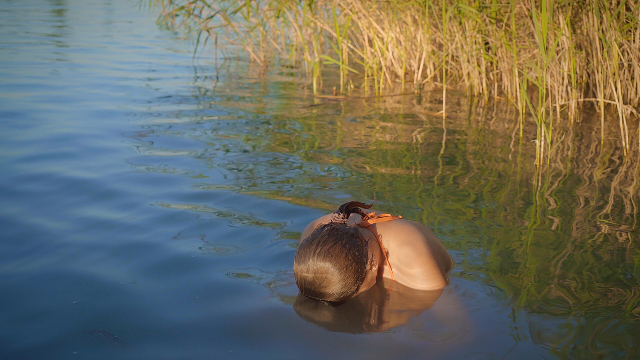 a woman in a lake with her face in the water