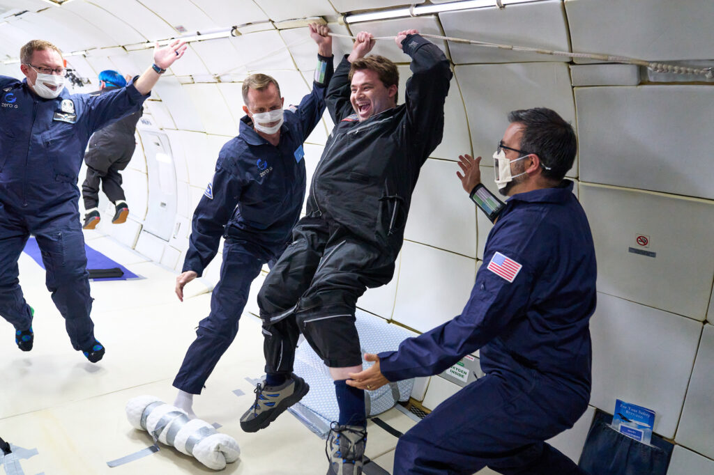 Photo of people in a spacecraft helping Rosenstein experience weightlessness