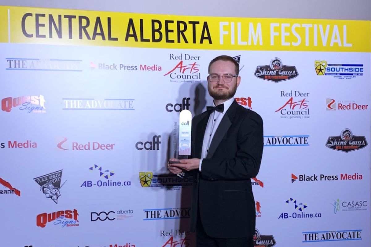Danny Chamberlin stands with his award at the Central Alberta Film Fest.
