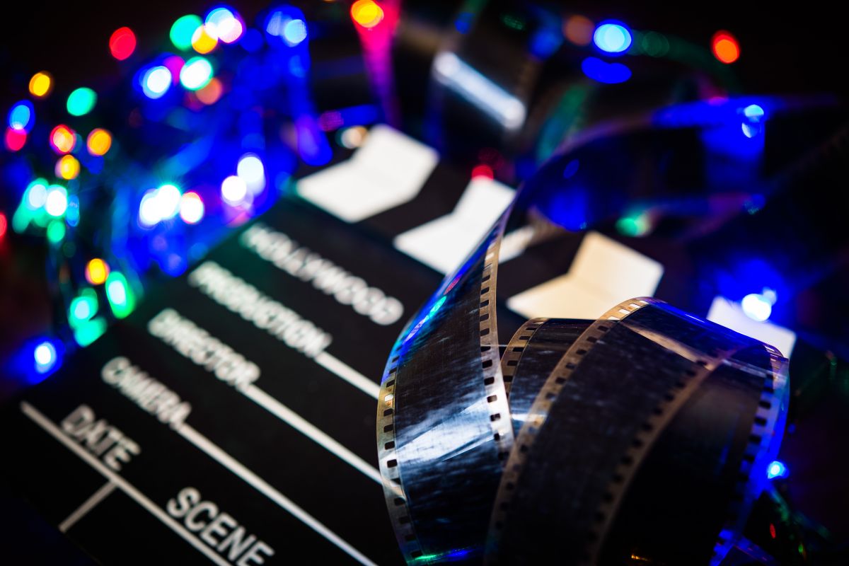 A film reel sits in a pile of blue and red christmas lights.