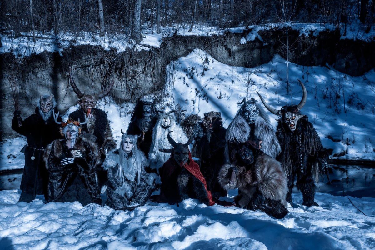 a group of people dressed as krampus stand in the snow