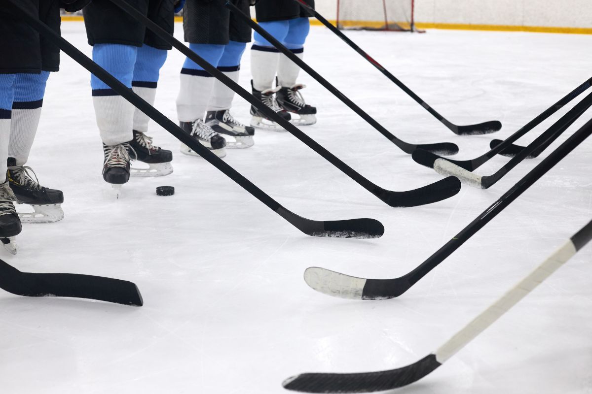 close up of hockey sticks and skates on the ice