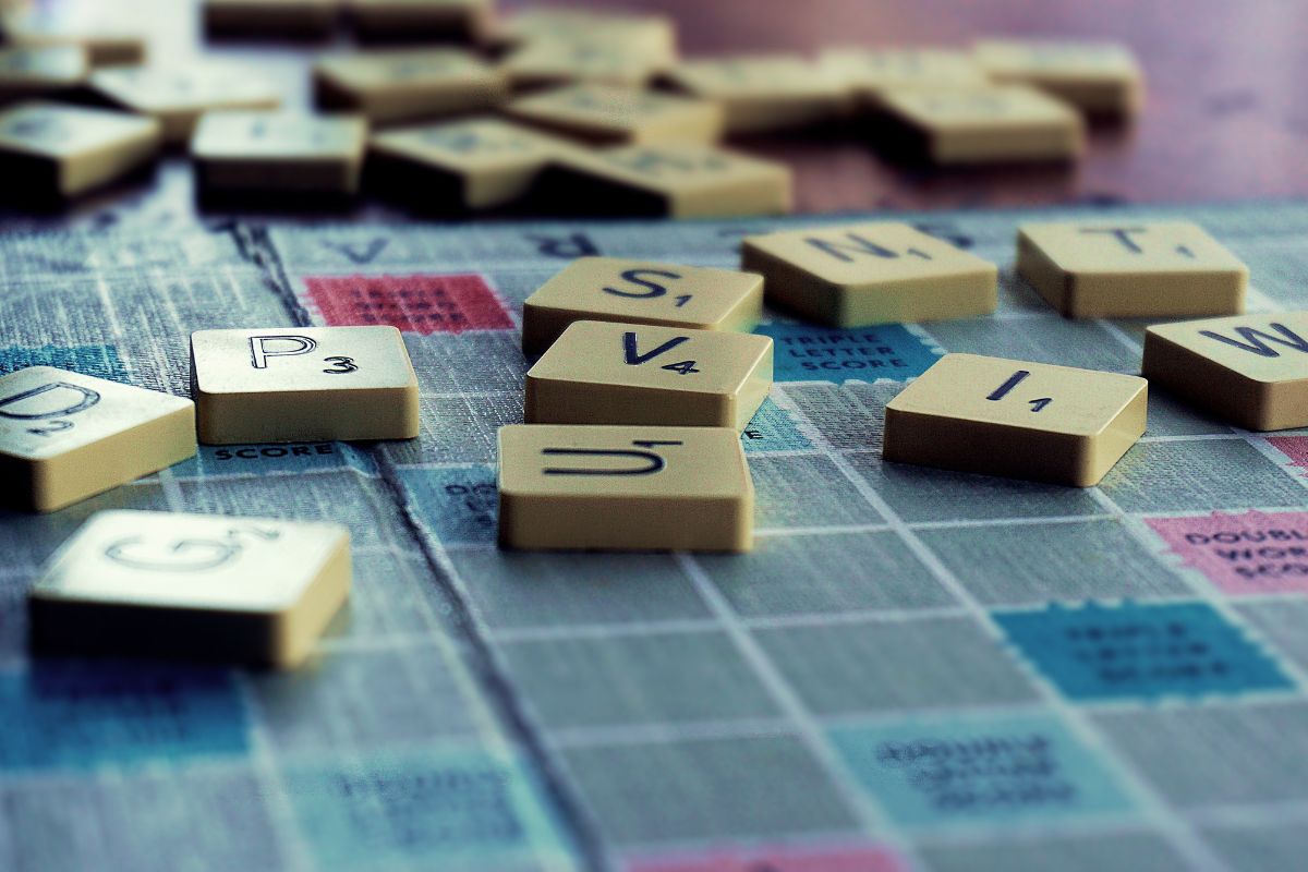 a close up shot of scrabble tiles spilled over a scrabble board