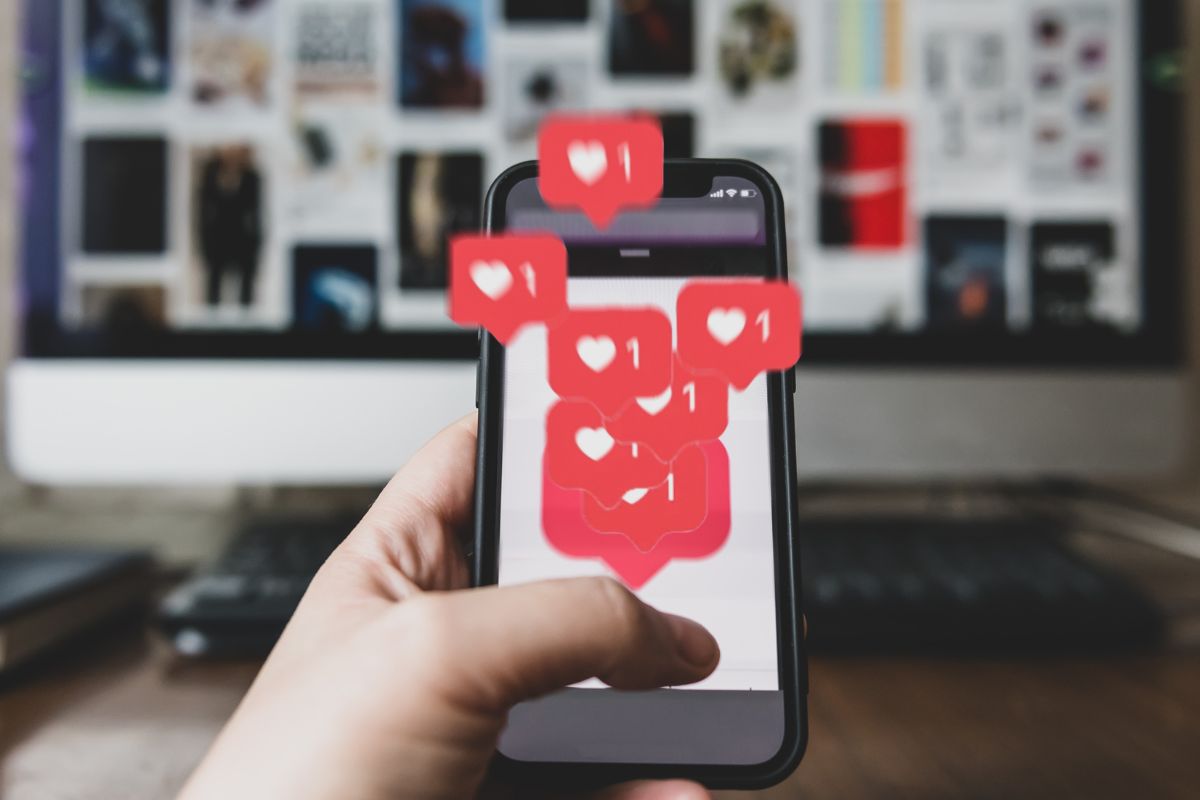 a person holds a phone with hearts shooting out of it